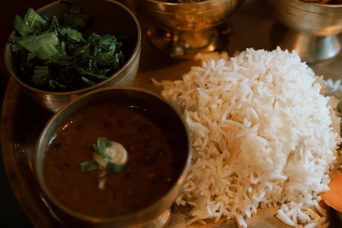 A close-up of a traditional indian meal with rice and dal.